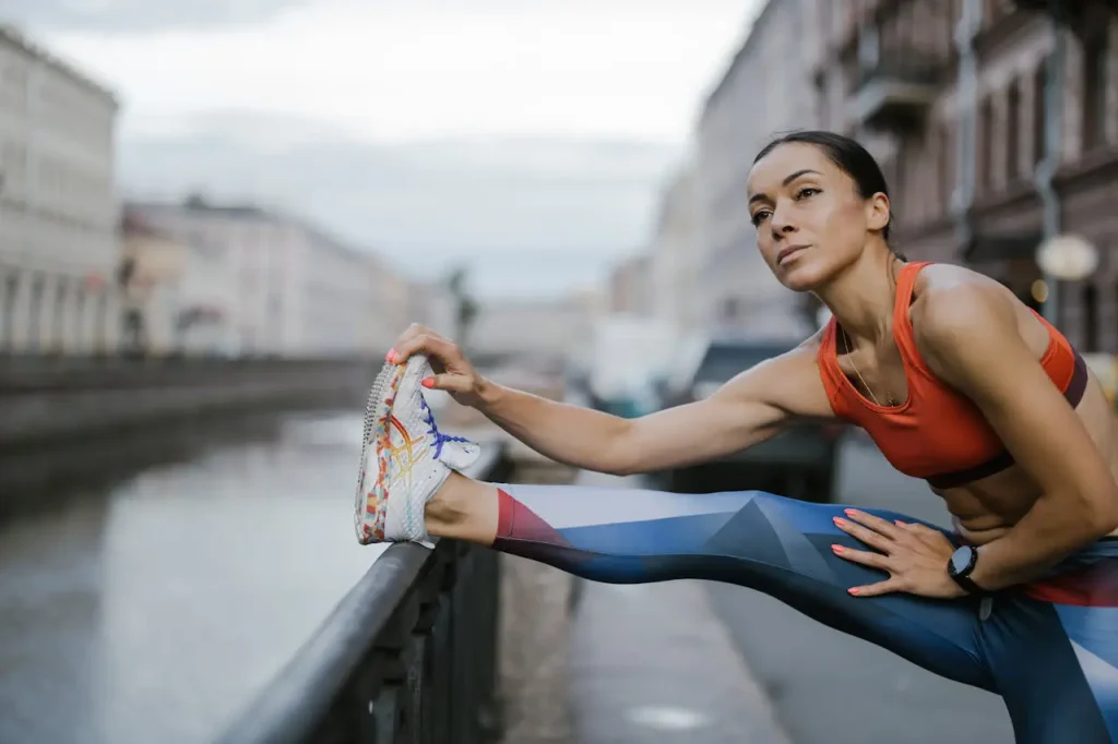 Best Early Morning Workouts to Beat the Summer Heat 2 A Woman Wearing Leggings and Sports Bra while Stretching Her Legs